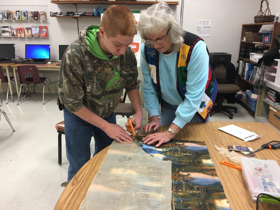 boy and an older woman cutting fabric